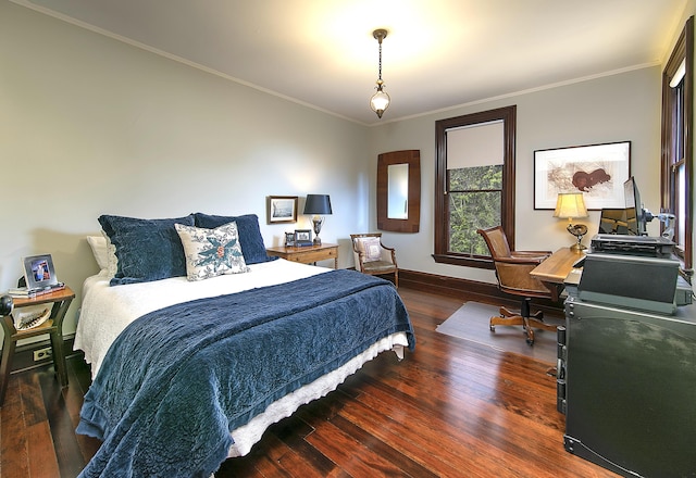 bedroom with dark wood-type flooring and ornamental molding