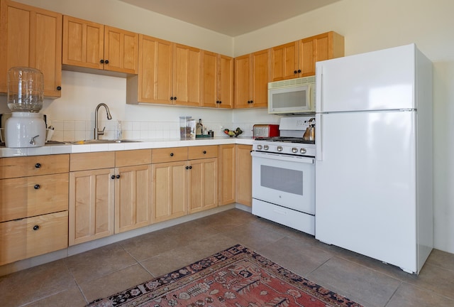 kitchen featuring light brown cabinets, white appliances, and sink