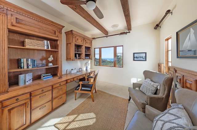 tiled home office featuring beam ceiling, ceiling fan, and built in desk