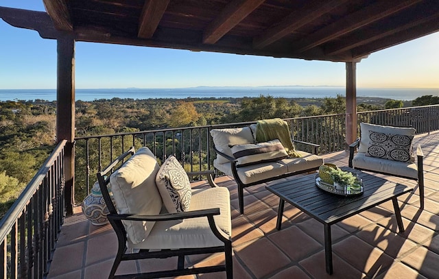 balcony featuring outdoor lounge area and a water view