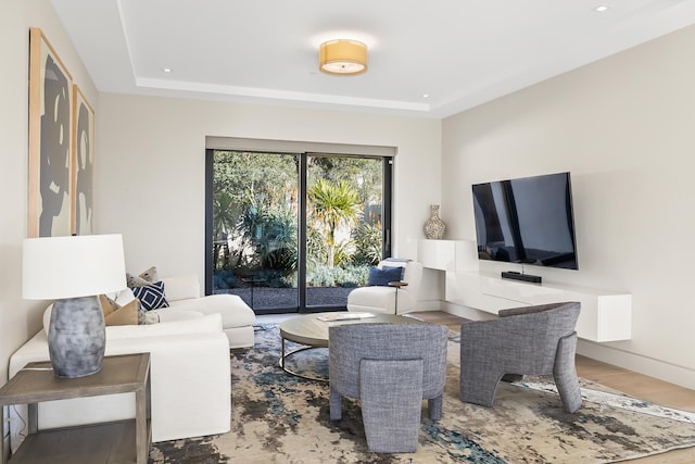 living room featuring hardwood / wood-style flooring and a raised ceiling