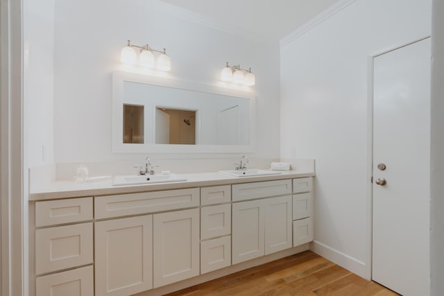 bathroom featuring vanity, wood-type flooring, and ornamental molding