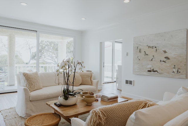 living room with crown molding and light hardwood / wood-style floors