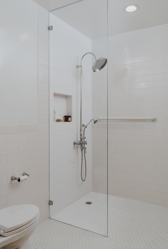 bathroom with tiled shower and toilet