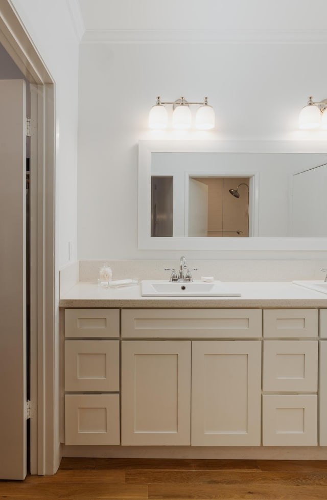 bathroom with vanity, hardwood / wood-style floors, and crown molding