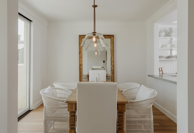 dining area with crown molding and light hardwood / wood-style floors