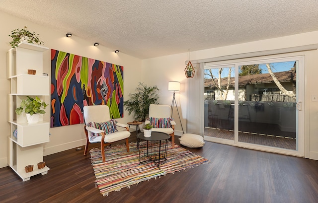 sitting room with a textured ceiling and dark hardwood / wood-style floors