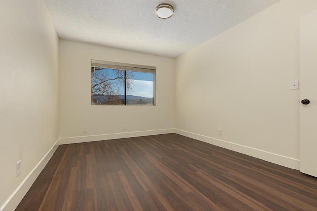 unfurnished room featuring a textured ceiling and dark hardwood / wood-style floors