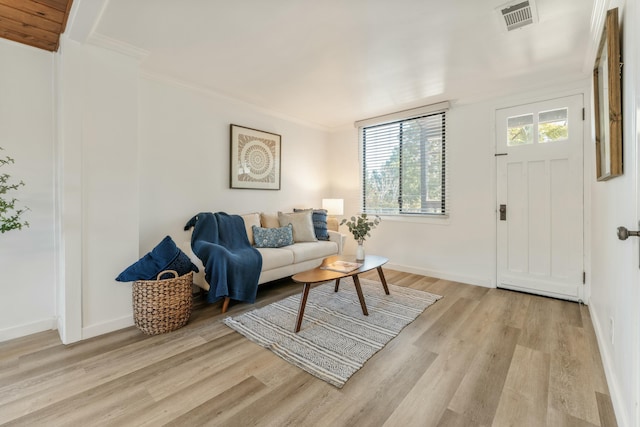 living room featuring light hardwood / wood-style floors and crown molding