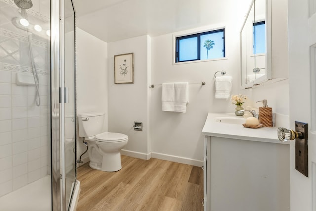 bathroom featuring a shower with shower door, toilet, vanity, and wood-type flooring