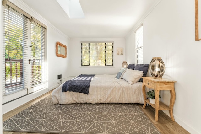 bedroom featuring multiple windows, a skylight, and ornamental molding