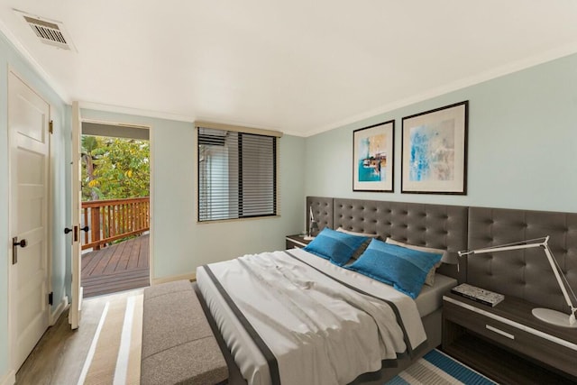 bedroom with ornamental molding, light wood-type flooring, and access to exterior