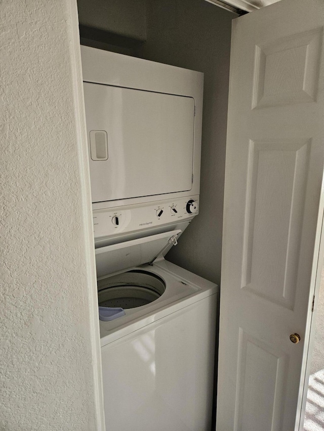 washroom featuring stacked washer / dryer