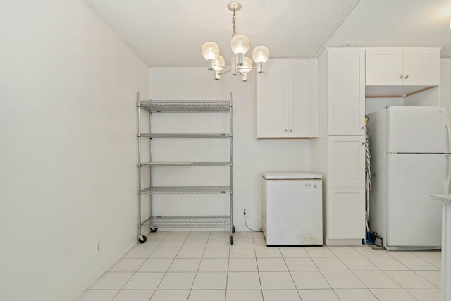 kitchen with white cabinetry, an inviting chandelier, decorative light fixtures, refrigerator, and white fridge