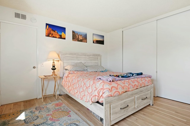 bedroom with light hardwood / wood-style flooring and a closet