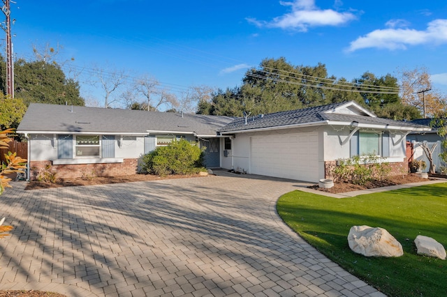 ranch-style home featuring a garage and a front lawn