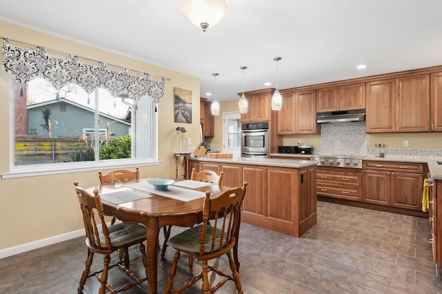 kitchen featuring decorative light fixtures, a kitchen island, stainless steel gas stovetop, and backsplash