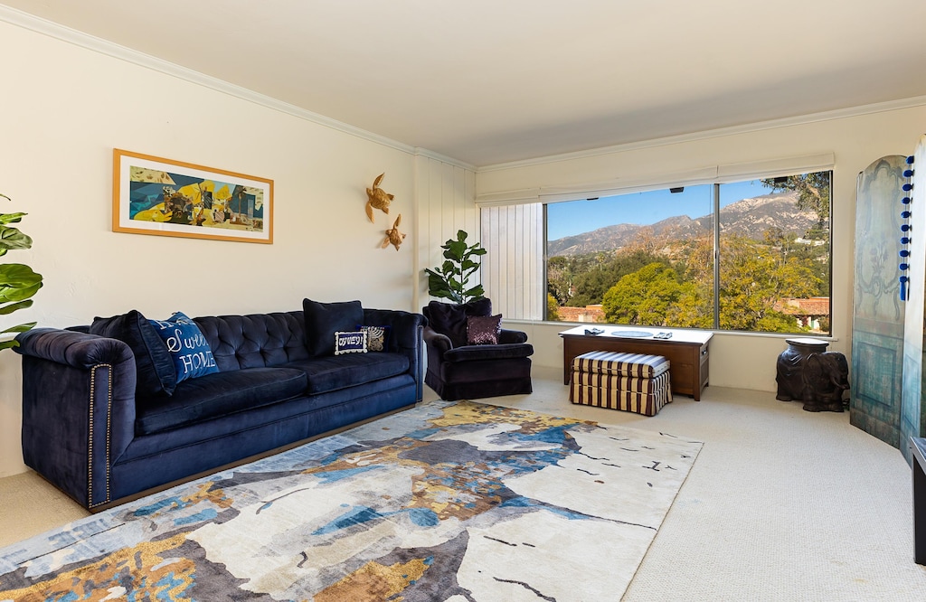 living room with crown molding, a mountain view, and carpet