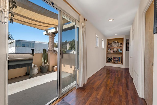 interior space with built in shelves and dark hardwood / wood-style floors