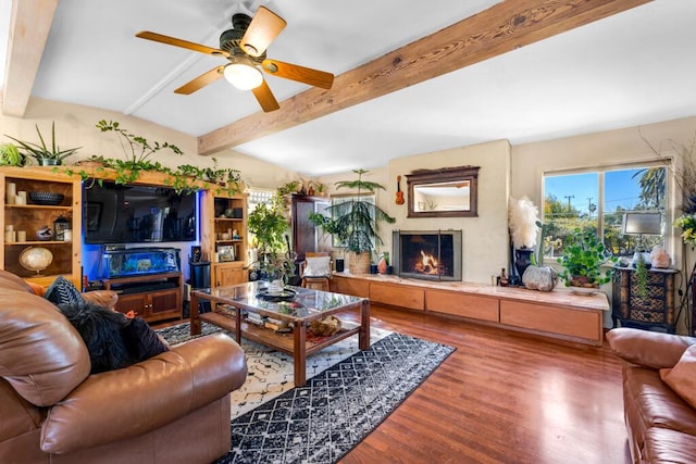 living room with ceiling fan, hardwood / wood-style flooring, and beamed ceiling