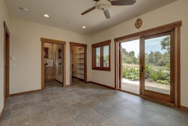 interior space with access to outside, baseboards, stone tile floors, and recessed lighting