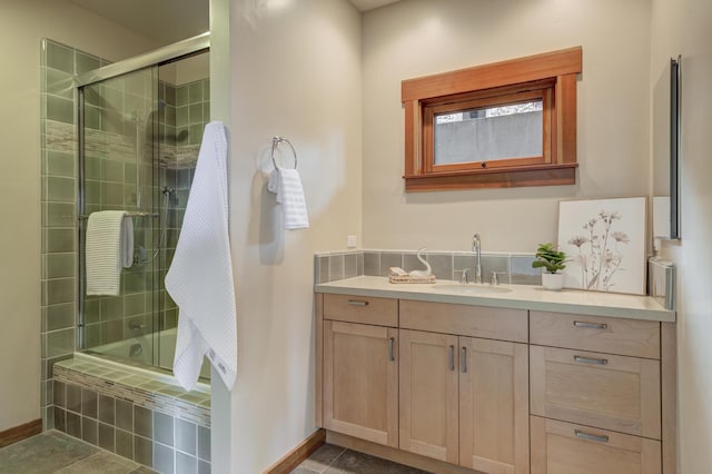 bathroom featuring tiled shower / bath combo, vanity, and baseboards