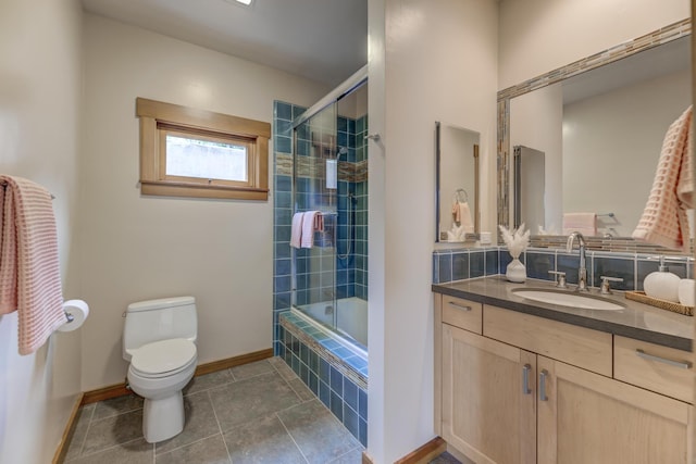 full bath featuring toilet, vanity, baseboards, tiled shower / bath, and tile patterned floors