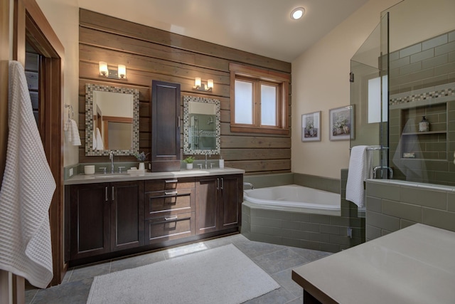 full bath with a garden tub, double vanity, tiled shower, and a sink