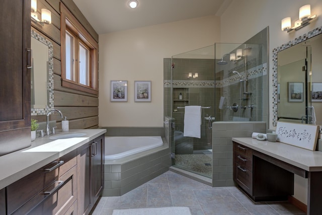 full bath with a garden tub, two vanities, a stall shower, a sink, and tile patterned flooring