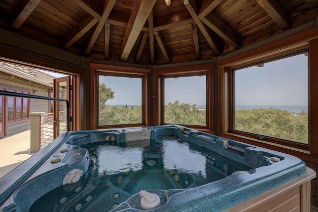 interior space with vaulted ceiling with beams, wood ceiling, and a jacuzzi