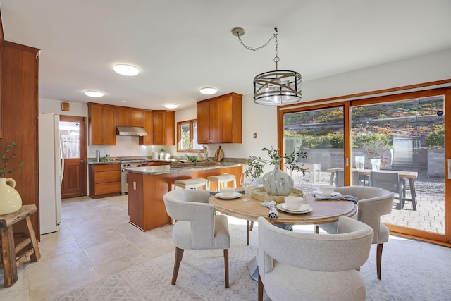 tiled dining room with an inviting chandelier