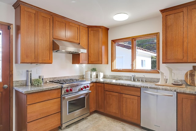 kitchen featuring appliances with stainless steel finishes, sink, light tile patterned floors, and light stone counters