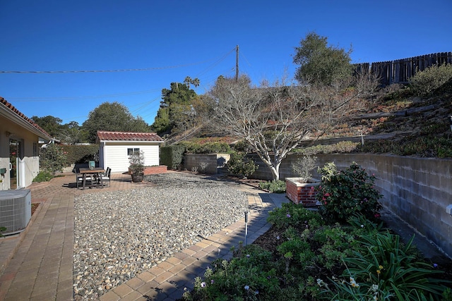 view of yard featuring a patio area, central air condition unit, and a storage shed