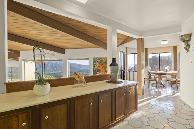 kitchen with wooden ceiling, dark brown cabinetry, beamed ceiling, and a mountain view