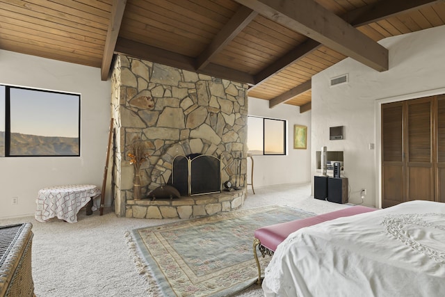 carpeted bedroom featuring wooden ceiling, beamed ceiling, a closet, high vaulted ceiling, and a stone fireplace