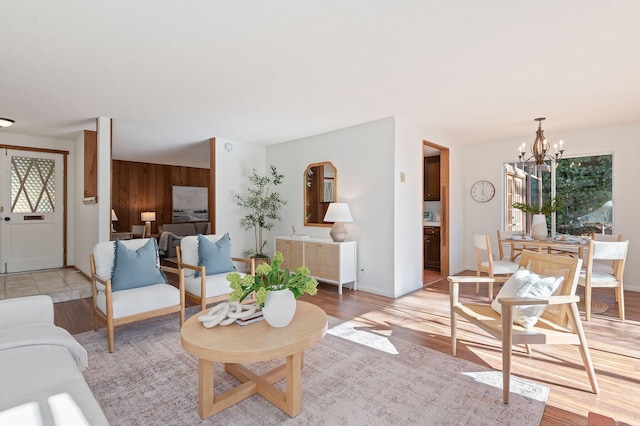 living room featuring wooden walls, a chandelier, and light hardwood / wood-style flooring