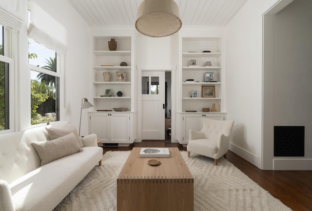 sitting room with wooden ceiling, dark wood-type flooring, and built in shelves