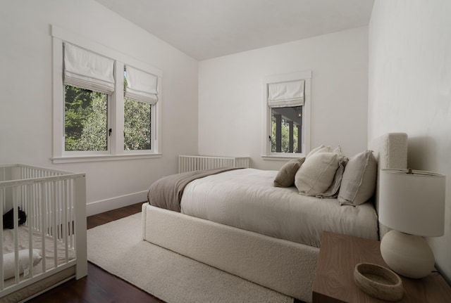 bedroom featuring dark hardwood / wood-style floors and multiple windows