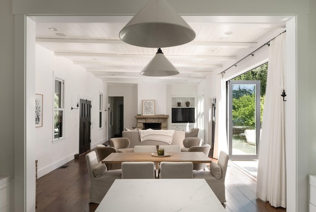 living room with dark hardwood / wood-style flooring, beam ceiling, and built in shelves