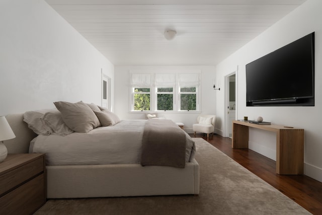 bedroom with dark hardwood / wood-style floors