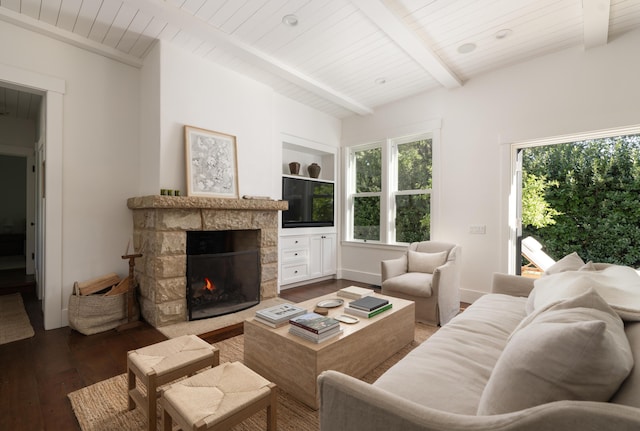 living room with wooden ceiling, hardwood / wood-style flooring, a stone fireplace, and beamed ceiling