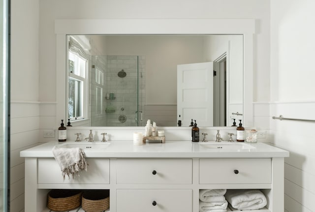 bathroom featuring a shower with shower door and vanity