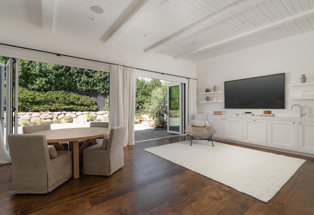 unfurnished living room featuring sink, dark hardwood / wood-style floors, and beamed ceiling