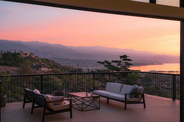 deck at dusk featuring an outdoor hangout area and a mountain view