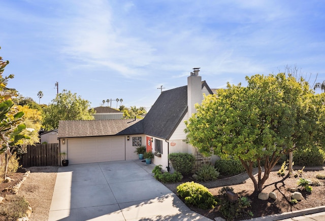 view of front of house with stucco siding, a shingled roof, concrete driveway, an attached garage, and fence