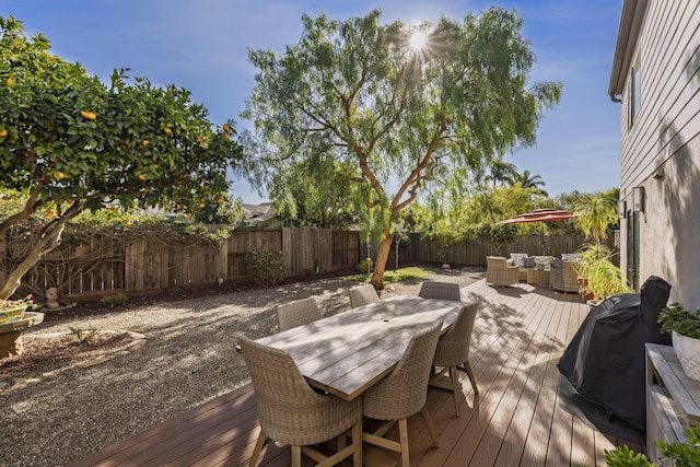 wooden terrace featuring outdoor dining area, a fenced backyard, an outdoor hangout area, and grilling area