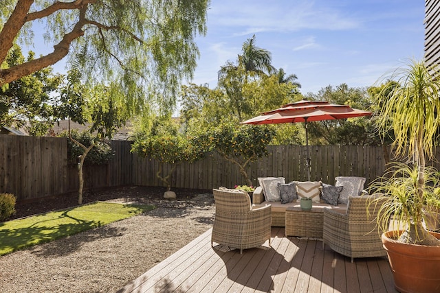 wooden deck featuring outdoor lounge area and a fenced backyard