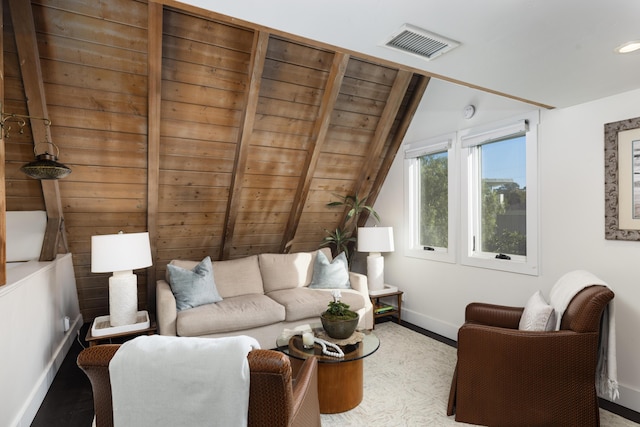 living room with lofted ceiling with beams, baseboards, visible vents, and wood finished floors