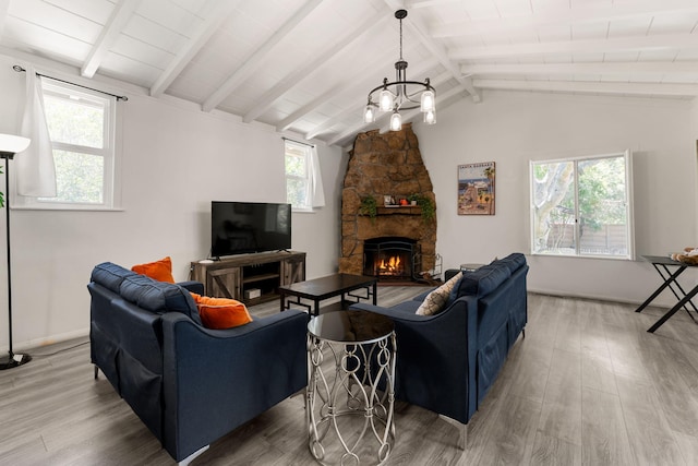 living room featuring a notable chandelier, a fireplace, hardwood / wood-style floors, and vaulted ceiling with beams