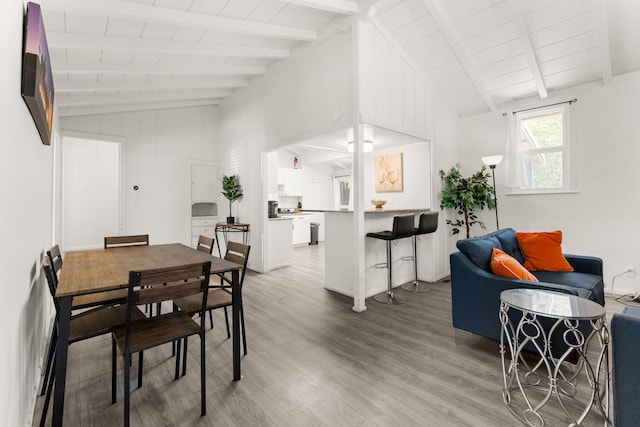 dining space with vaulted ceiling with beams, wood ceiling, and hardwood / wood-style floors